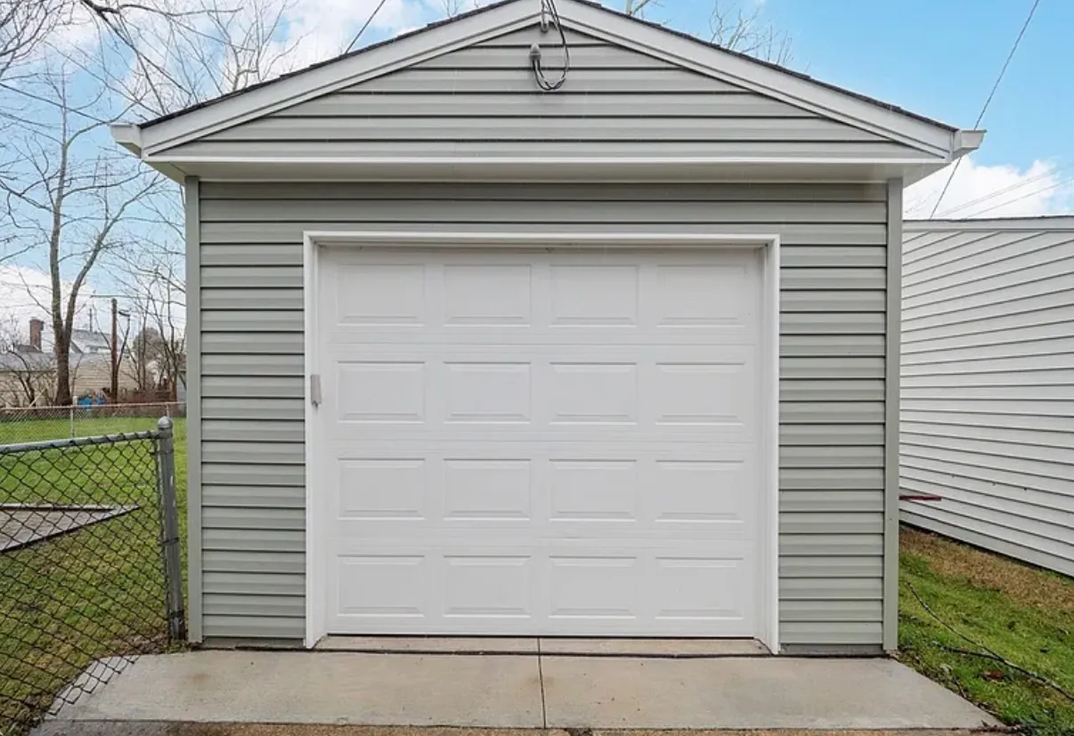 Detached garage with new siding, a new overhead door and a concrete apron